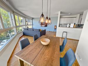 uma sala de jantar e sala de estar com uma mesa de madeira e cadeiras em ARISER - Zug Central Business Apartment em Zug