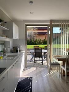 a kitchen and dining room with a table and chairs at Rizling Apartmanház**** Balatonalmádi in Balatonalmádi