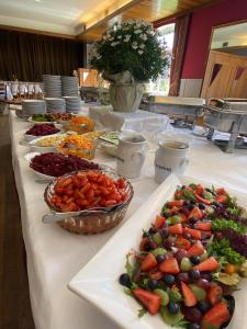 une longue table avec des assiettes de nourriture dans l'établissement Sauerland Hotel & Gastronomie GmbH, 