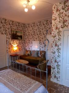 sala de estar con sofá y papel pintado con motivos florales en 13 Bohemian Bienvenue B&B, en Pontrieux