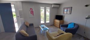 a living room with a couch and chairs and a tv at Phare View in Marseillan