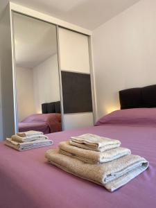 una pila de toallas sentadas en una cama frente a un espejo en Apartmani Antonia, en Račišće