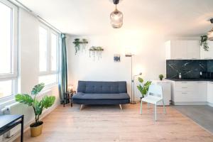 salon z niebieską kanapą i kuchnią w obiekcie Charming Central Cityflats w Antwerpii