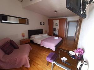 a room with two beds and a couch and a tv at Guest House Mijo Sokol in Brela