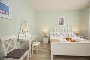 ein weißes Schlafzimmer mit einem Bett, einem Waschtisch und einem Spiegel in der Unterkunft Villa Ivana in Labin