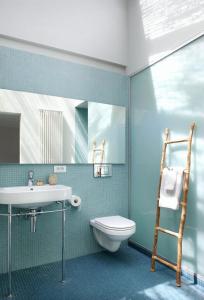 a bathroom with a sink and a toilet and a ladder at midiSud Apartment in Ghent