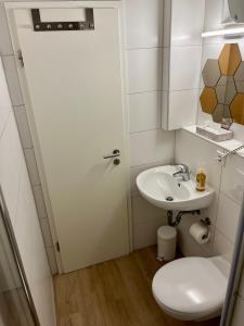 Baño blanco con aseo y lavamanos en Ferienwohnung Washingtonweg en Hannover