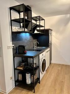 een keuken met een wastafel en een wasmachine bij Ferienwohnung Washingtonweg in Hannover
