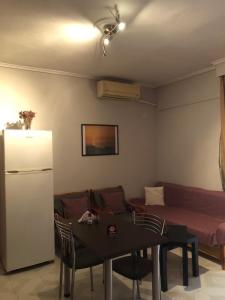 ein Wohnzimmer mit einem Sofa, einem Tisch und einem Kühlschrank in der Unterkunft Aleka's House in Thessaloniki