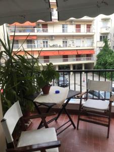 einen Tisch und Stühle auf einem Balkon mit einem Gebäude in der Unterkunft Aleka's House in Thessaloniki