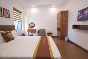 a bedroom with a bed and a tv on the wall at B & B Hotel Quan Hoa in Hanoi