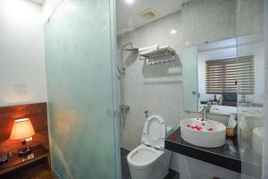 a bathroom with a toilet and a sink and a mirror at B & B Hotel Quan Hoa in Hanoi