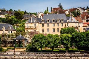 a large building with a gazebo in front of a city at Hôtel Restaurant de Bouilhac, Spa & Wellness - Les Collectionneurs in Montignac