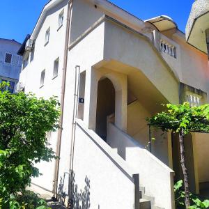 a white building with stairs in front of it at Apartmani Asanović in Budva