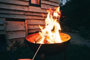ein Feuer in einem Topf vor einem Gebäude in der Unterkunft Empress En Suite Wagon in Arthog