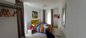 een slaapkamer met een bed met een kleurrijke deken bij Kalimera Guest House in Giardini Naxos