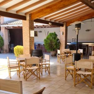 un patio con mesas y sillas en un edificio en Hostal Restaurante Dulcinea de El Toboso, en El Toboso