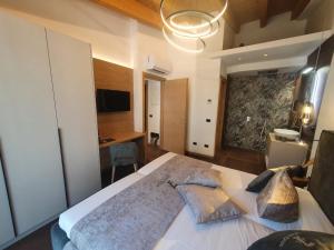 Un dormitorio con una gran cama blanca con almohadas. en Sibenbras Natural Aparthotel, en Limone sul Garda