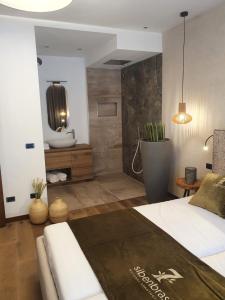 1 dormitorio con 1 cama grande y baño en Sibenbras Natural Aparthotel, en Limone sul Garda