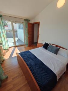ein Schlafzimmer mit einem großen Bett und einem großen Fenster in der Unterkunft Villa Sanja I in Trogir