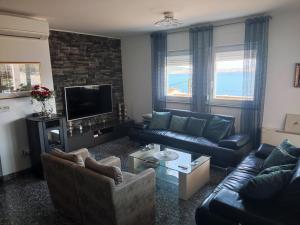 ein Wohnzimmer mit einem Sofa und einem TV in der Unterkunft Villa Sanja I in Trogir
