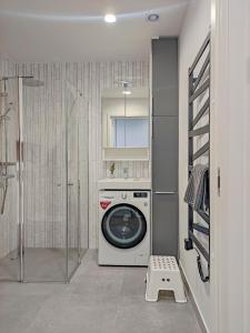 een wasruimte met een wasmachine en een wasmachine bij Comfy Rest apartamentai Kalno namuose in Juodkrantė
