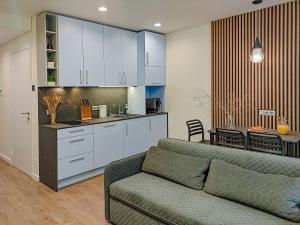 Il comprend un salon avec un canapé et une cuisine. dans l'établissement Comfy Rest apartamentai Kalno namuose, à Juodkrantė