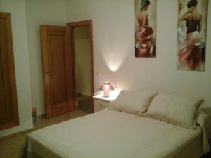 a bedroom with a bed and a lamp on a table at Sol y Luz in Caleta De Fuste