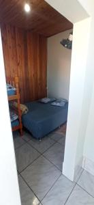 1 dormitorio con 1 cama azul en una pared de madera en Pousada Três Forquilhas, en Guananazes