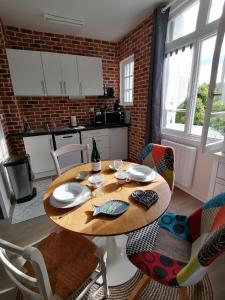 een eettafel met stoelen en een keuken bij A la "Georgette" et son jardin avec parking in Villers-sur-Mer