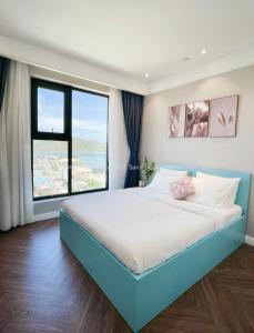 a bedroom with a large bed with a large window at ALTARA Residences Quy Nhơn-Sam n' Sea Apartment-Căn hộ homestay view biển có hồ bơi in Quy Nhon