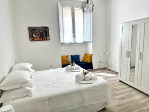 a white bedroom with a bed with towels on it at La casa di Ale nel centro storico di Cagliari in Cagliari
