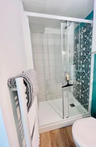 La salle de bains est pourvue d'une douche avec une porte en verre. dans l'établissement LE QUAI 6 - Studio neuf CALME LUMINEUX - CLIM - WiFi - Gare à 200m, à Agen