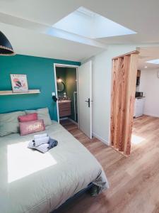 ein Schlafzimmer mit einem Bett und einer blauen Wand in der Unterkunft LE QUAI 6 - Studio neuf CALME LUMINEUX - CLIM - WiFi - Gare à 200m in Agen