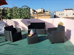 three chairs and a table on a roof at Rosa's Apartment with Terrace in Cagliari