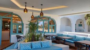 a lobby with a blue couch and tables and windows at Armonia in Kamari