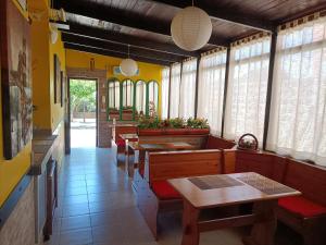 Mony's Island B&B في ألغيرو: غرفة طعام مع طاولات وكراسي ونوافذ
