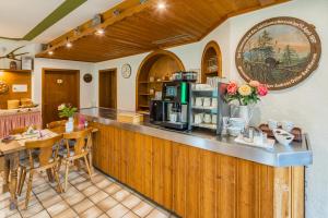 a kitchen with a bar with a table and chairs at Hotel-Pension-Ostler in Bad Wiessee