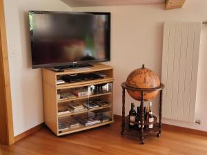 a flat screen tv on a stand with a table with wine bottles at Ferienwohnung Bally in Brunnen