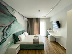 a bedroom with a bed and a painting on the wall at Vila Llanaj in Ksamil