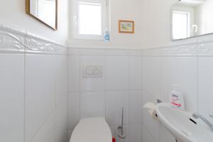 een witte badkamer met een toilet en een wastafel bij Komfort Ferienwohnung Steiger in Timmendorfer Strand