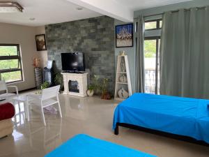 a living room with a blue bed and a tv at MountView studio in city in Port Louis