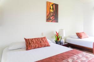 1 dormitorio con 2 camas y un cuadro en la pared en Hotel Vista del Cerro, en Fortuna