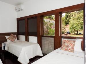2 camas en una habitación con ventana en Pousada Recanto do Turvo, en Capitólio