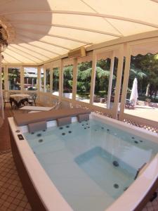 a large jacuzzi tub in a room with windows at Villa delle Querce Resort in Palo del Colle