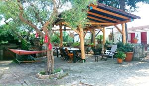 a wooden pergola with a table and chairs under it at B&b Parco Alta Murgia in Cassano delle Murge