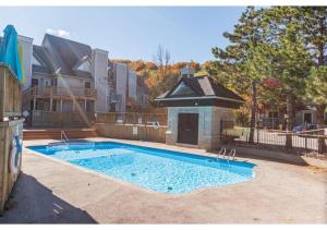 a swimming pool in front of a house at Mountainside River Dream. Walk to slopes, tennis, bike, ski, hot tub, pool! in Blue Mountains