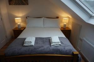 um quarto com uma cama com 2 candeeiros e toalhas em Whitehorse House em Donegal