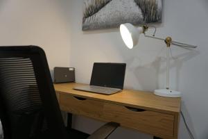 einen Schreibtisch mit Laptop und Lampe in der Unterkunft Whitehorse House in Donegal