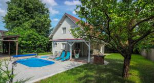 a house with a swimming pool in the yard at Oliva 8 fős Balatoni Nyaraló in Balatonakarattya